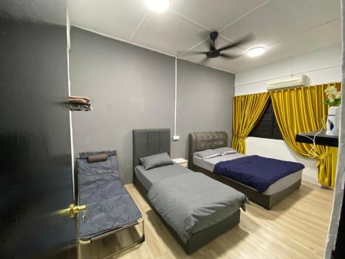 PagohPagoh Town Homestay的客房设有两张床和吊扇。