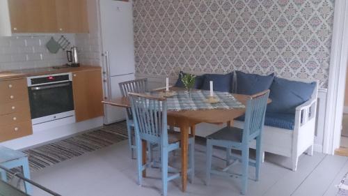 HedemoraRöda stugan的一间带木桌和椅子的厨房以及一间用餐室