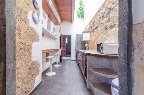 大加那利岛拉斯帕尔马斯Flatguest Amiga Mia - Traditional House的厨房设有石墙和台面
