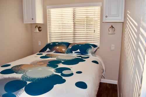 萨拉索塔Pinecraft Blue Heron Tiny Home的一间卧室配有一张带蓝色和白色棉被的床