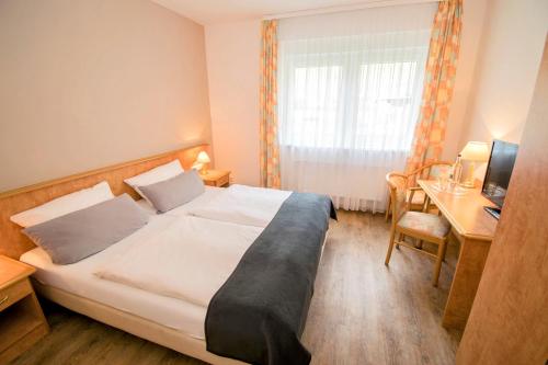 摩泽尔肯林格斯汀讷木勒兰德酒店的配有一张床和一张书桌的酒店客房