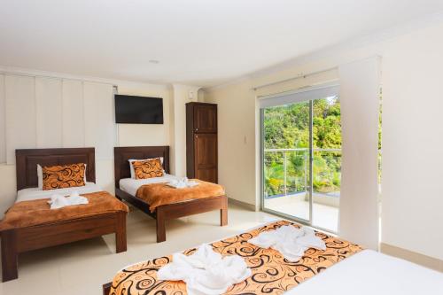 瓜塔佩Hotel Verony Guatape的一间卧室设有两张床和窗户。