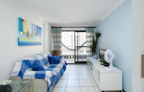 福塔莱萨Iracema Apartament的客厅配有沙发和带风扇的书桌。