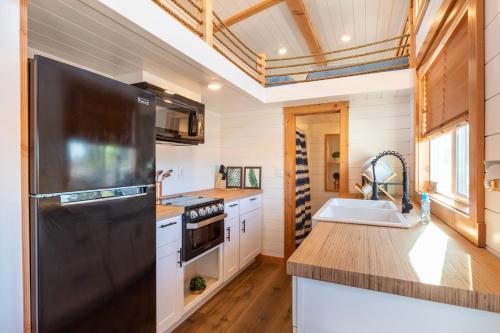 Apple ValleyAloha Tiny Home的厨房配有黑色冰箱和水槽