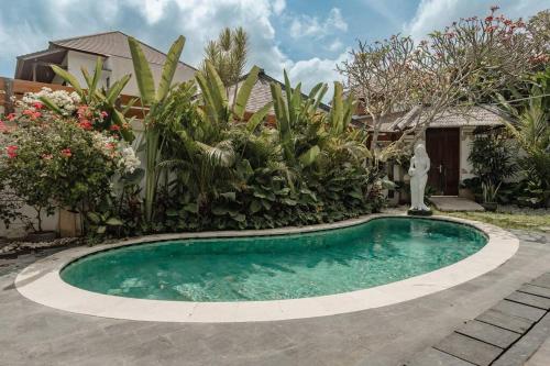 登巴萨Villa Nelayan Sands的一座带花园的房屋前的游泳池