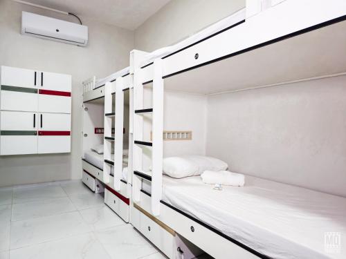 纳塔尔MANERO POUSADA e HOSTEL的卧室配有白色双层床和白色橱柜。