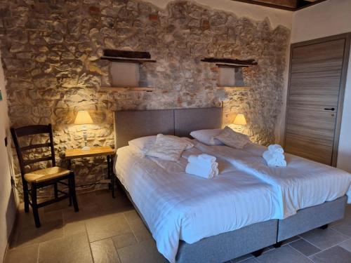 TarzoAgriturismo La Pina的一间卧室设有一张床和石墙