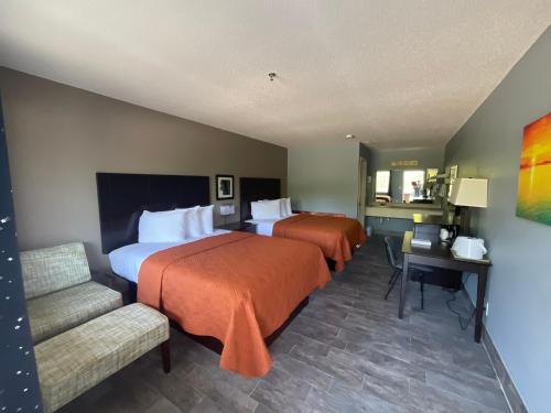 布兰森SUNSET INN的酒店客房,设有两张床和一张沙发