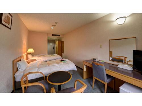 松江市Yuuai Kumanokan - Vacation STAY 27598v的酒店客房带一张床、一张书桌和一面镜子