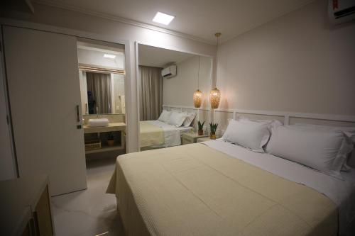 福塔莱萨Flat Beira Mar的卧室配有一张白色大床和镜子
