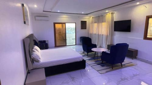 达喀尔BI HOTEL 2的卧室配有一张床和一张桌子及椅子