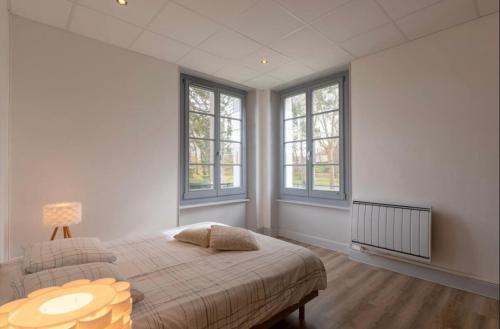 内里莱班Résidence Harmonie Appartement N 3 Meublé Avec Petit Déjeuner的一间卧室配有一张带桌子和窗户的床。
