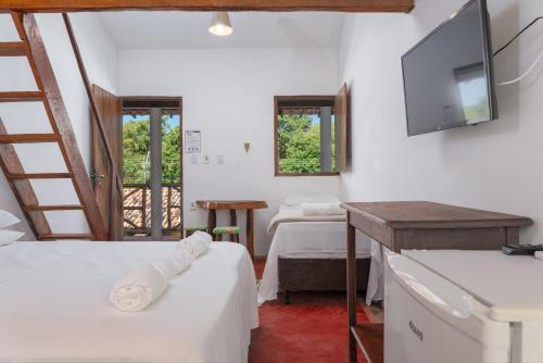 普拉亚弗朗西丝Pousada Trilha do Mar的客房设有两张床和一台平面电视。