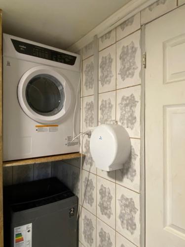 Habitación para 4, acogedor, familiar, equipado, baño compartido的厨房里设有洗衣机和烘干机,墙上有
