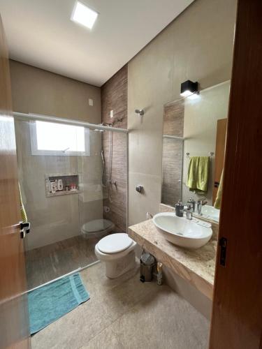 瓜拉廷格塔Quartos privativos - Casa de alto padrão的一间带水槽、卫生间和淋浴的浴室