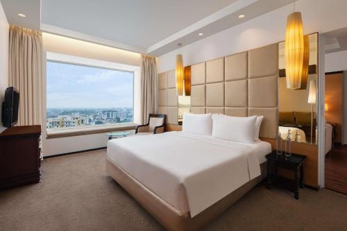 兰奇兰契丽笙酒店的卧室设有一张白色大床和大窗户