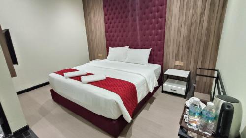 峇六拜科伦姆美景酒店的一间卧室配有一张大床和红色床头板