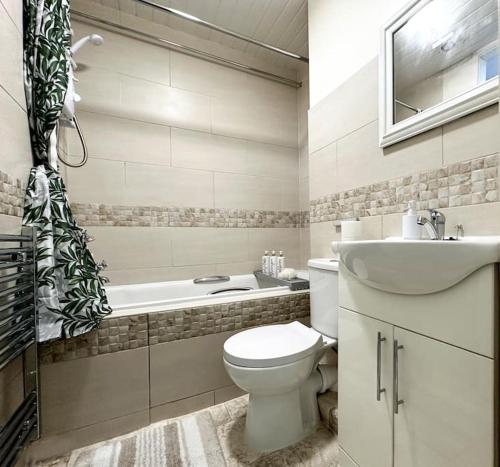 Joyful Jungle Jewel w/Balcony & Foozeball-Ferndale的浴室配有卫生间、盥洗盆和浴缸。
