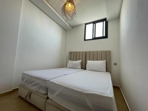塔哈佐特Surfside Studio in Taghazout 2-3px的一间卧室配有一张带白色床单的床和一扇窗户。