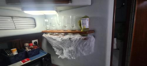 巴塞罗那Boat to sleep in Barcelona的墙上装有酒杯的架子