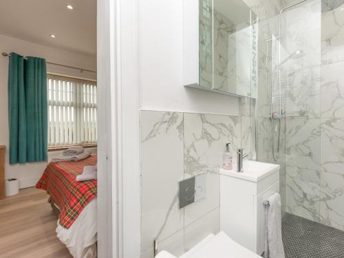 KingstonInverspey的带淋浴的浴室和客房内的一张床