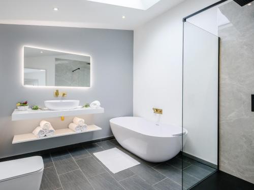 SantonMarshall Cottage的白色的浴室设有浴缸和水槽。