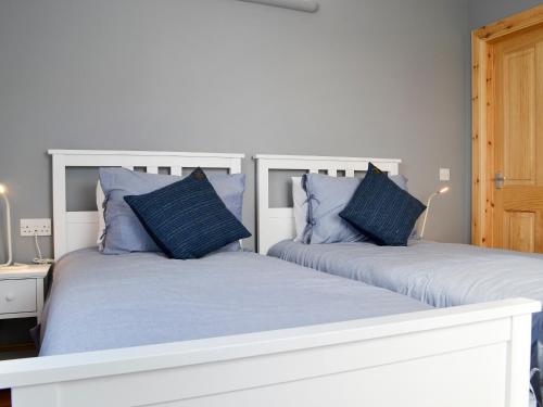GarrabostHealair的卧室内的两张床和蓝色枕头