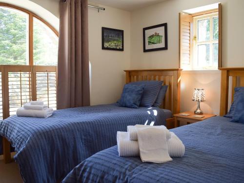 TalleyBarn Cottage的一间卧室设有两张床和窗户。