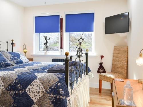 康内尔4 Dolphins的一间卧室配有一张带蓝色窗帘的床和电视。