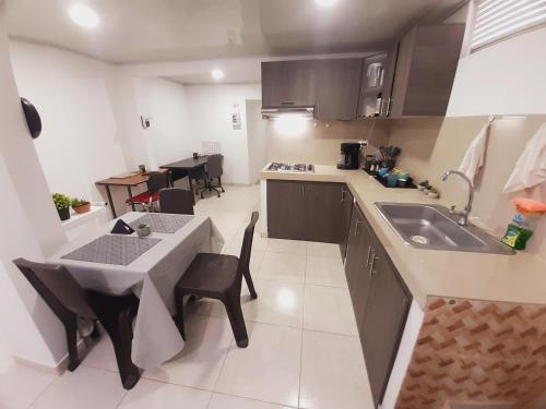 波帕扬Apartamento en centro de Popayán的厨房配有桌子、水槽和桌椅