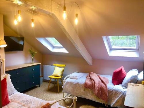 BickingtonLemon Cottage的阁楼卧室设有两张床和两个天窗。