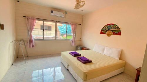 涛岛Lotus Hostel Beach Koh Tao的一间卧室配有一张带紫色毛巾的床