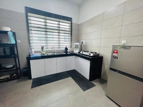 马六甲Insyirah Homestay Melaka的厨房配有水槽和冰箱