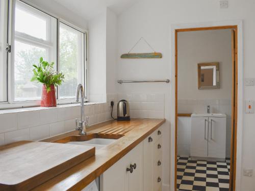 WhitwellElm Cottage的白色的厨房设有水槽和窗户