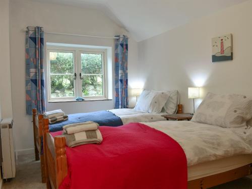 WhitwellElm Cottage的一间卧室设有两张床和窗户。