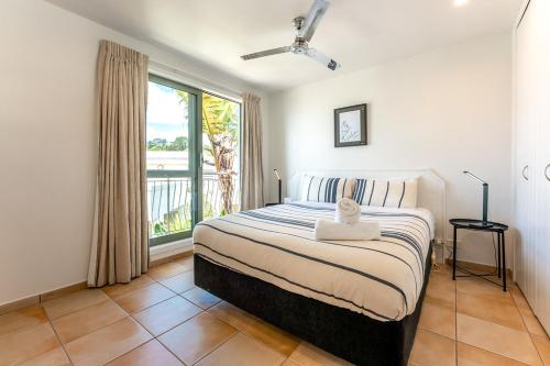 欧尼坦基旺唐伊海滩公寓的一间卧室设有一张床和一个大窗户