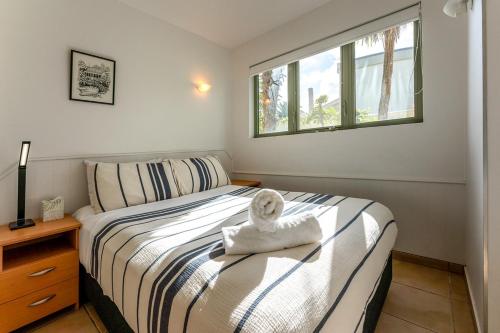 欧尼坦基旺唐伊海滩公寓的一间卧室配有一张床,床上有毛巾