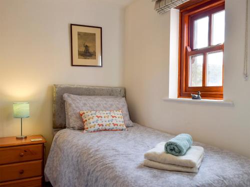 斯基普顿Mallards Nest的一间卧室配有一张带枕头和窗户的床