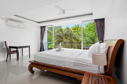 普吉镇4 bedrooms & bathroom for up to 12 guests 7kms to Patong beach at The Fairways golf villas的一间卧室设有一张床和一个大窗户