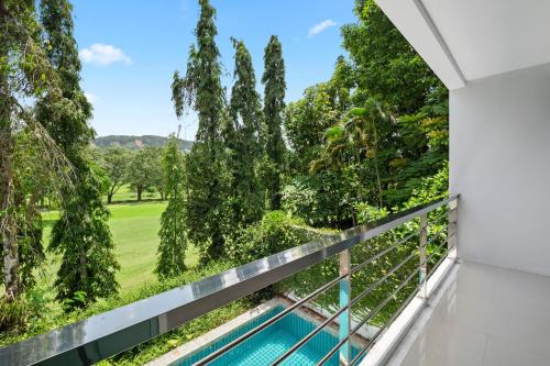 普吉镇4 bedrooms & bathroom for up to 12 guests 7kms to Patong beach at The Fairways golf villas的阳台享有游泳池和树木的景致。