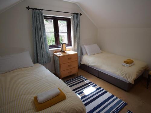 克里克豪厄尔Dardy Cottage的一间小卧室,配有两张床和窗户