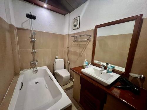 琅勃拉邦Lakhang Thong Hotel的带浴缸、水槽和镜子的浴室