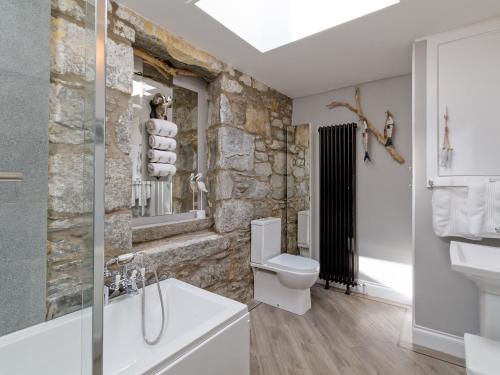 牛顿斯图尔特Creebank的浴室设有石墙、卫生间和水槽。