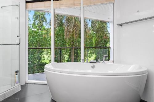 卡图The Fairways Villas - 4 bedroom for 10 guests - 7kms to Patong beach的带窗户的浴室内的白色浴缸
