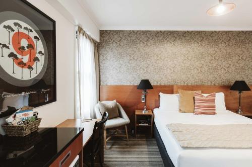 新普利茅斯斯塔特酒店的配有一张床和一把椅子的酒店客房