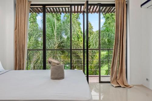卡图The Fairways Villas - 4 bedroom for 10 guests - 7kms to Patong beach的一间卧室设有一张床和一个大窗户