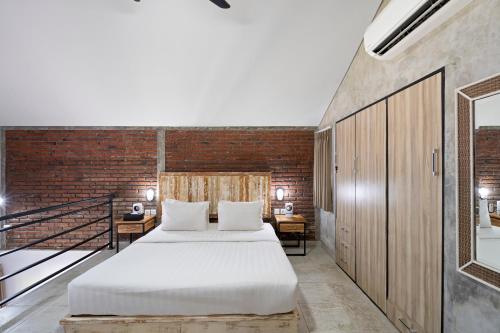 坎古Ambara U6 Loft by Hombali的一间卧室设有一张床和砖墙