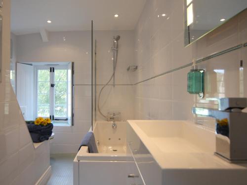 廷特恩Tintern Abbey Cottage的白色的浴室设有浴缸和水槽。