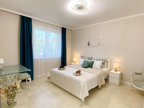 鲍洛托瑙考利Luna Rossa Boutique Apartman的卧室设有一张白色大床和一扇窗户。