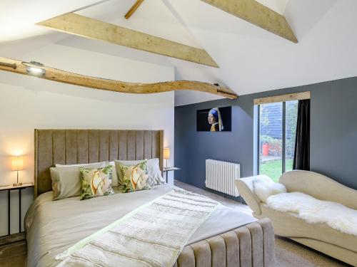 Saint Osyth1 Lamb Barn的一间卧室配有一张大床和一张沙发